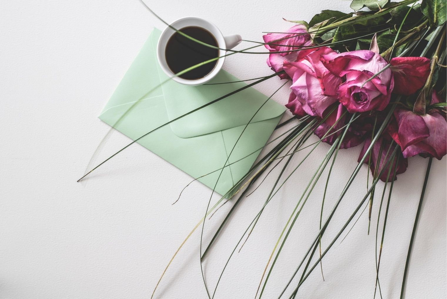 Flowers and envelope with coffee mug, receiving gifts