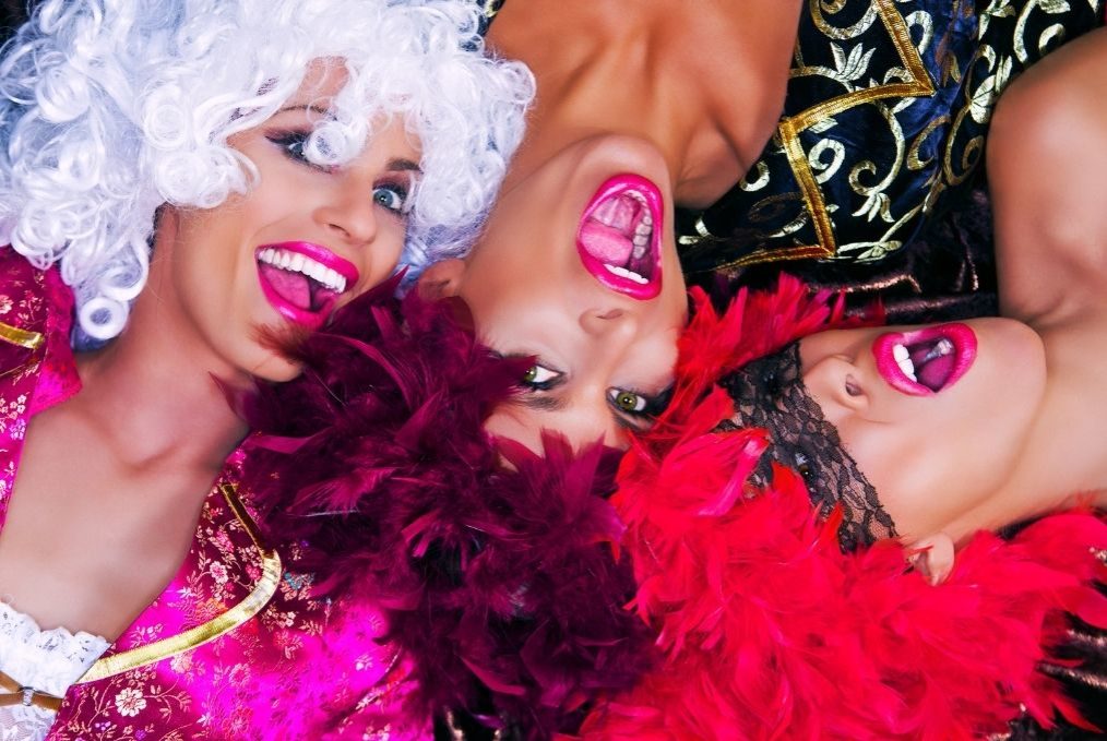 Three women smiling in colourful threesome