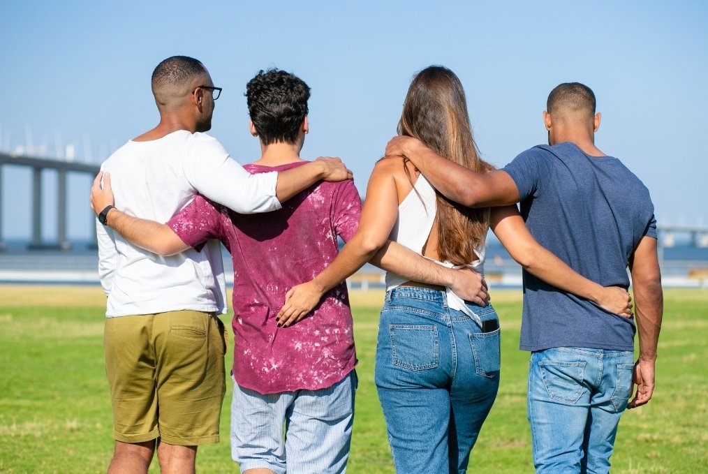 4 people walking holding around each other. Ethical non-monogamy.